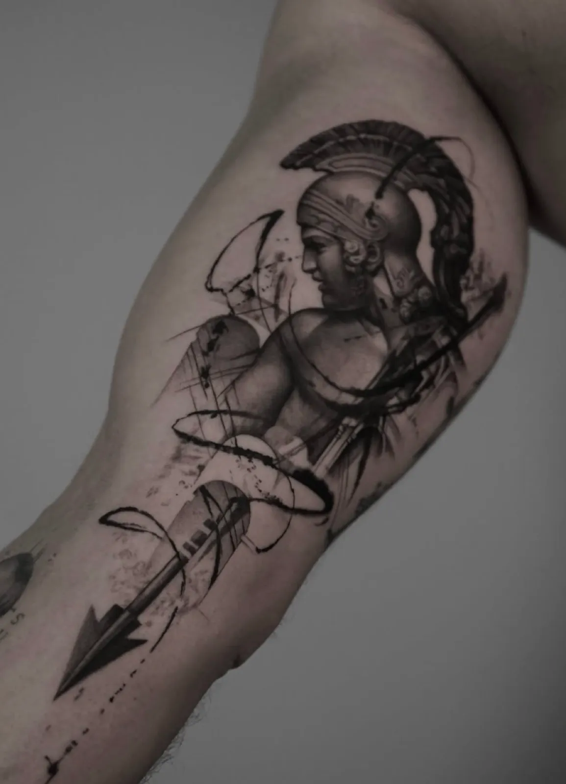 Ares con lanza, blackwork y trazos de tinta en el brazo